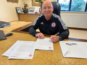 Andy Holt, Chair of Accrington Stanley FC signing invitation letters for 39 local primary schools