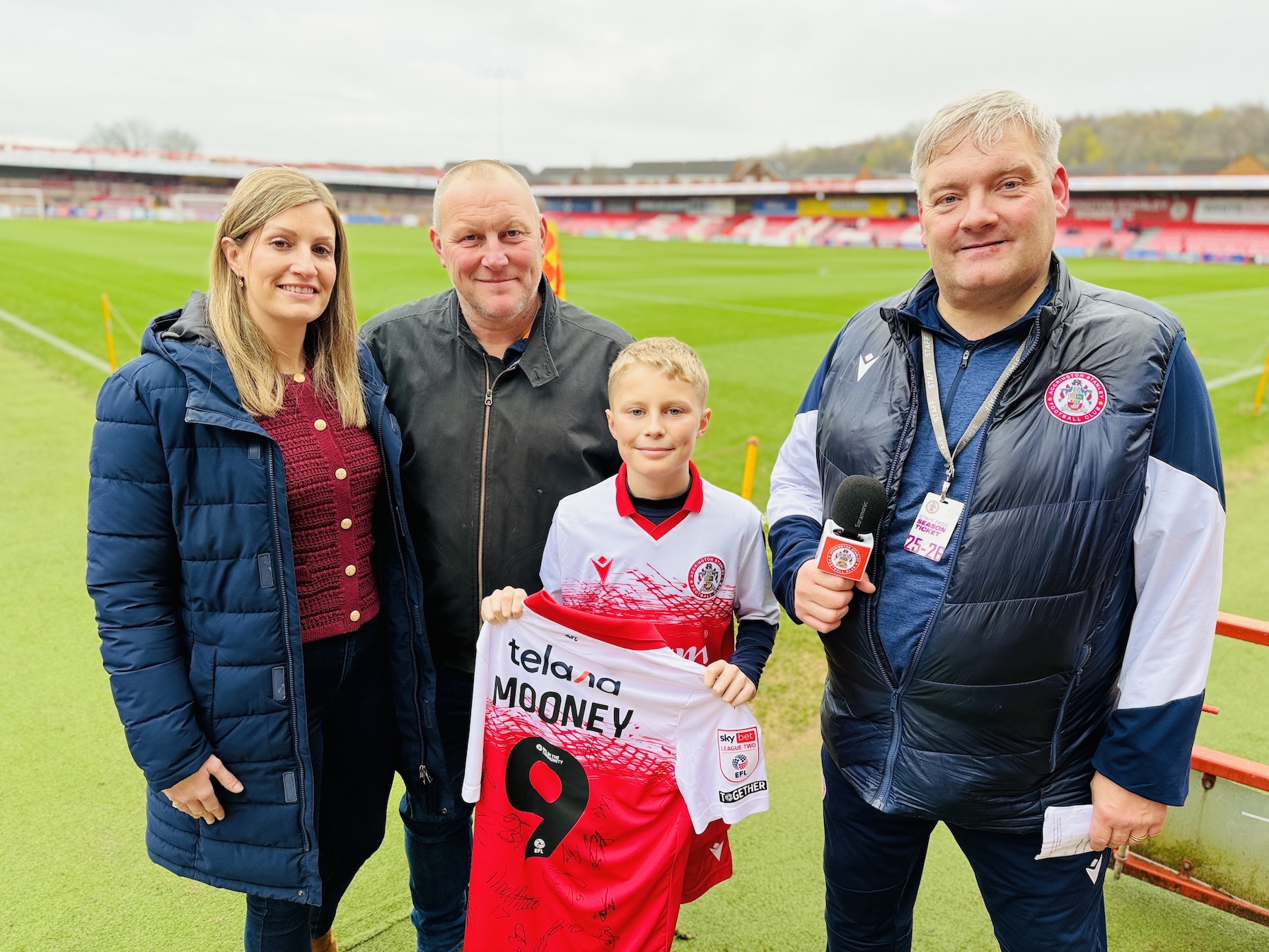 Young fan Isaac Taylor pitchside with his family and Accrington Stanley supporter liaison officer Robert Houseman